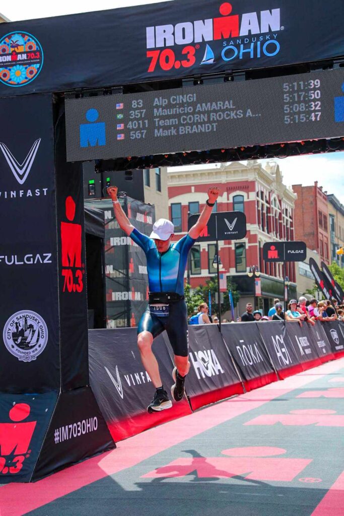 man jumping as he crosses Ironman 70.3 finish line