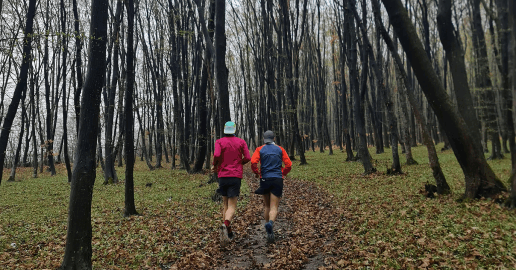 Two people running in the fall on a trail