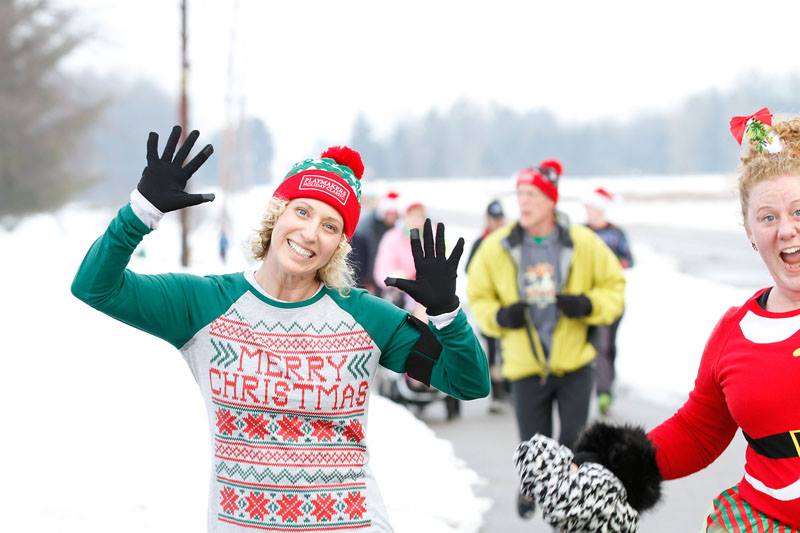 woman running in festive holiday gear smiling