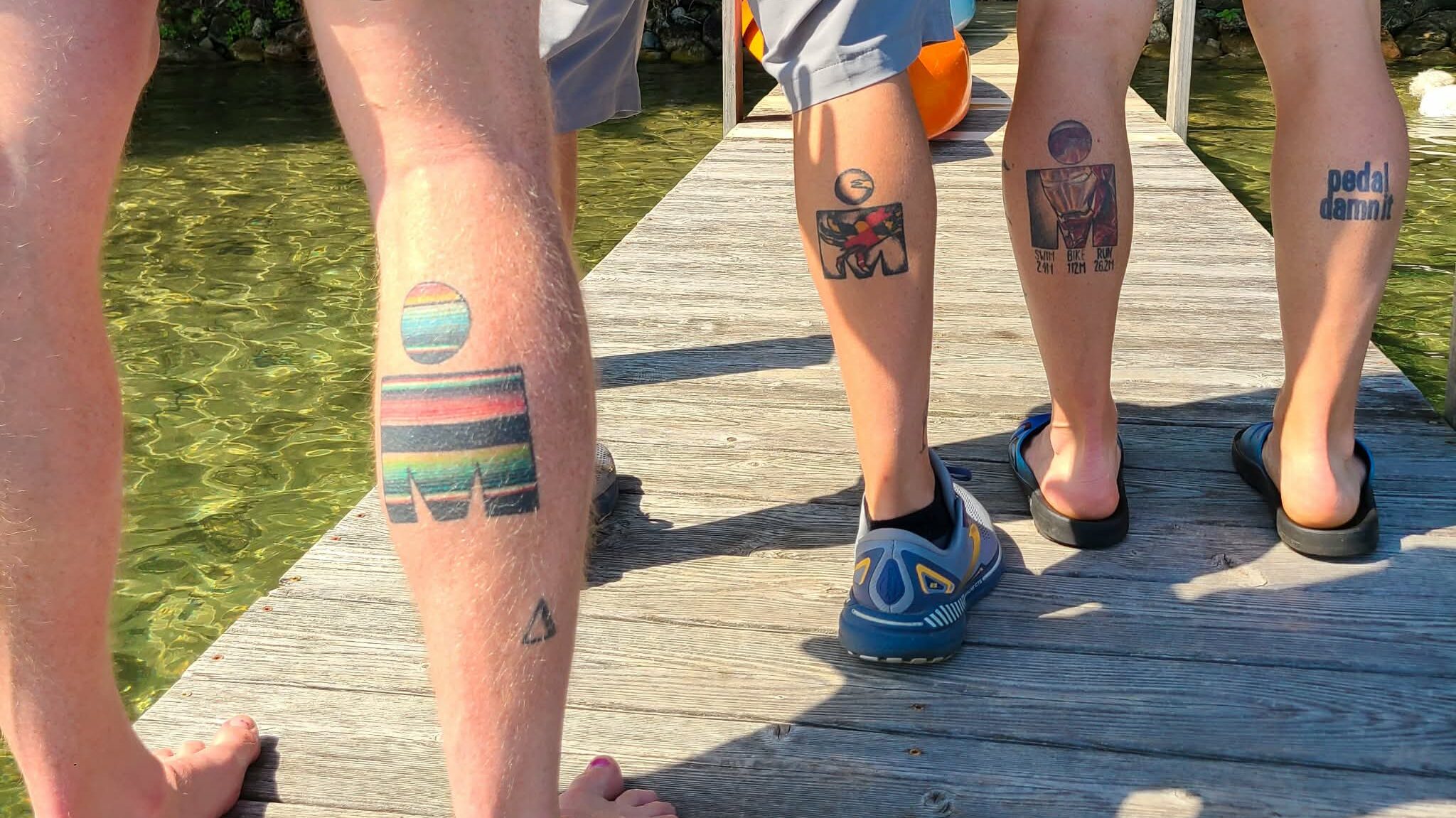 three men with ironman tattoos on their calf