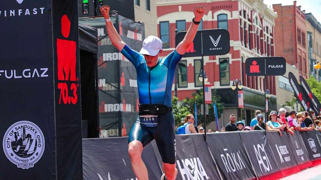 man jumping as he crosses Ironman 70.3 finish line